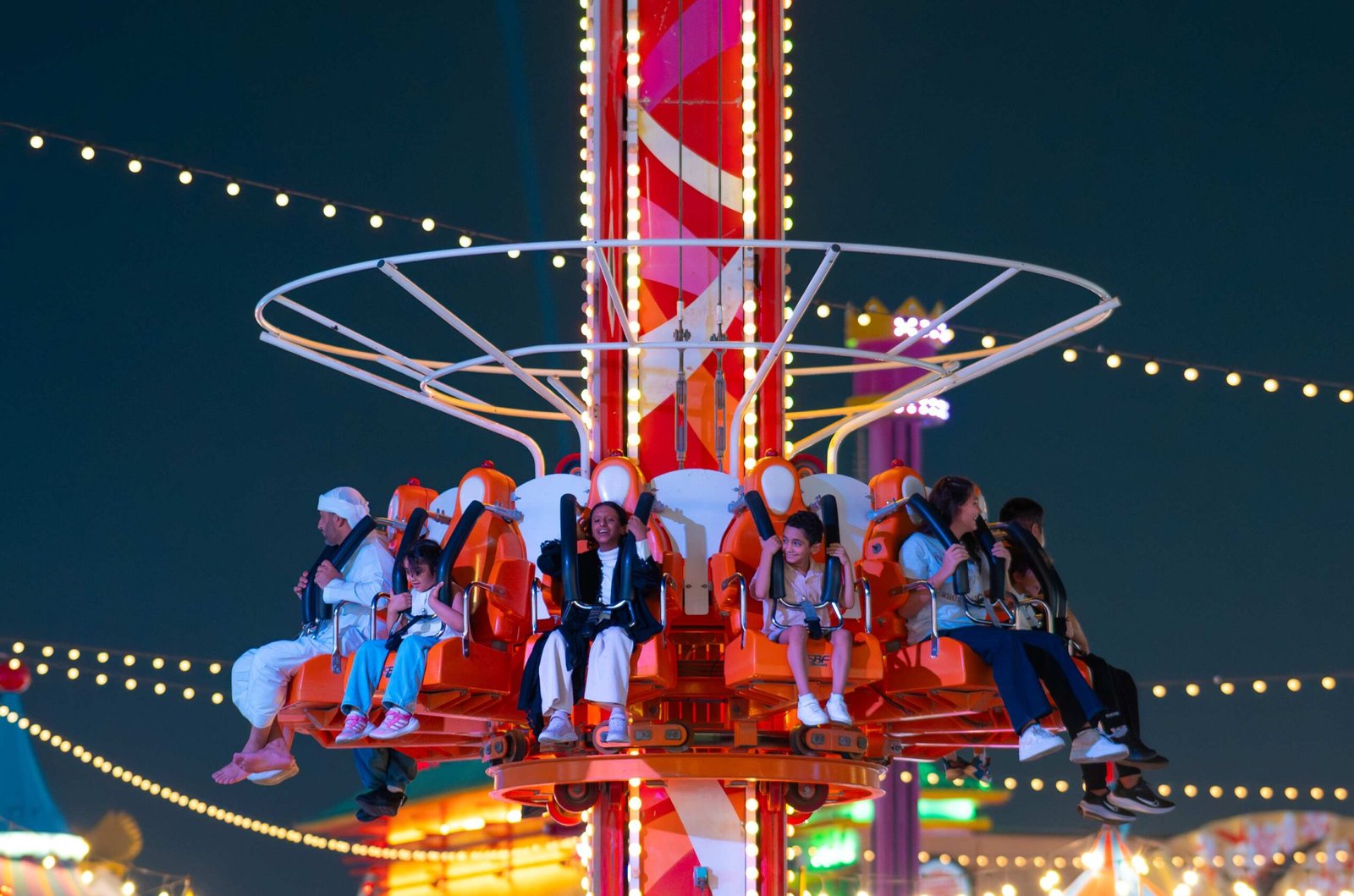 High-energy Global Village rides and neon lights at Carnaval Dubai.