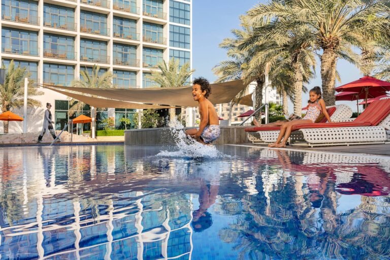Happy family enjoying a beachfront Yas Island staycation in Abu Dhabi.