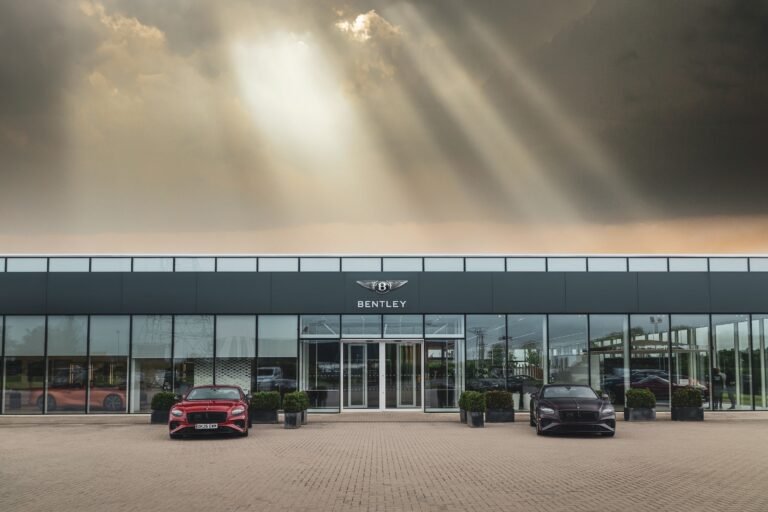 Modern luxury vehicles on display at the entrance of Bentley factory tours in Crewe.
